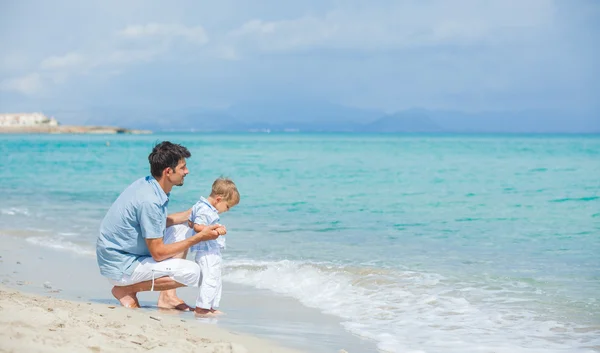 Lycklig far och hans son som spelar på stranden — Stockfoto