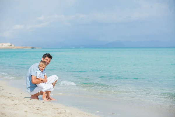 Счастливый отец и его сын играют на пляже — стоковое фото