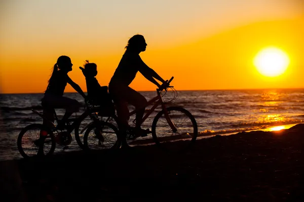 stock image Mother and her kids on the bicycle silhouettes