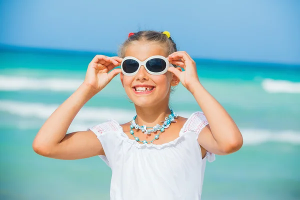 Дівчина в сонцезахисних окулярах розслабляє океанський фон — стокове фото