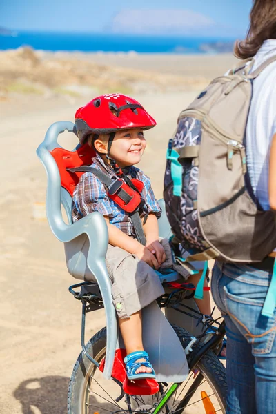 Child sitting by bicycle in crash helmet — Stock Photo, Image