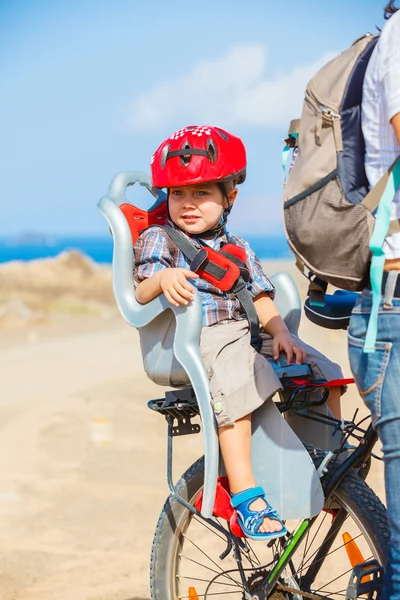 Criança sentada de bicicleta em capacete de choque — Fotografia de Stock