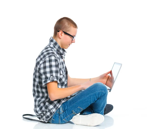 Καθισμένος νεαρός χρησιμοποιώντας ένα φορητό υπολογιστή — Φωτογραφία Αρχείου