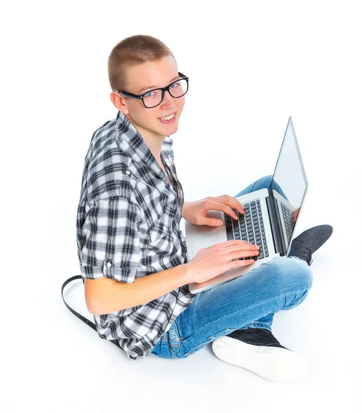 Bir dizüstü bilgisayar kullanarak oturan genç adam — Stok fotoğraf