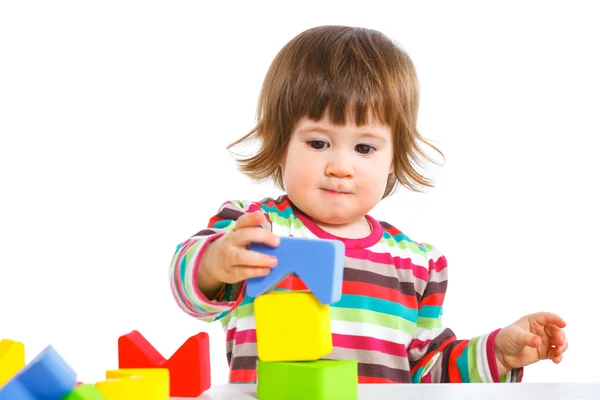Smiling little girl is building — Stock Photo, Image