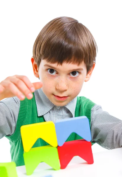 Smiling little boy is building — Stock Photo, Image