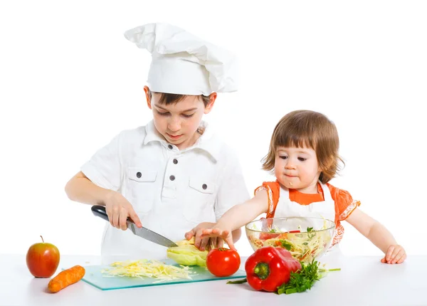 Two smiling kids mixing salad — Stock Photo, Image