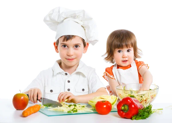 Dos niños sonrientes mezclando ensalada —  Fotos de Stock