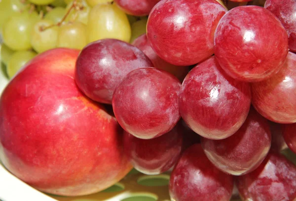 Rote, gelbe Trauben und roter Apfel — Stockfoto