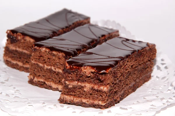 Três bolo de chocolate com creme e esmalte de chocolate — Fotografia de Stock