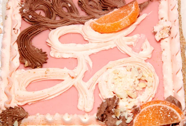 Песок торт с розовой глазурью, конфеты фрукты и сливки — стоковое фото