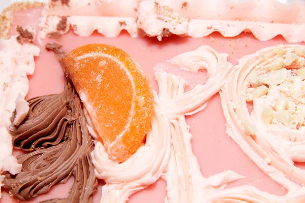 Zand cake met roze ijsvorming, gekonfijt fruit en room — Stockfoto