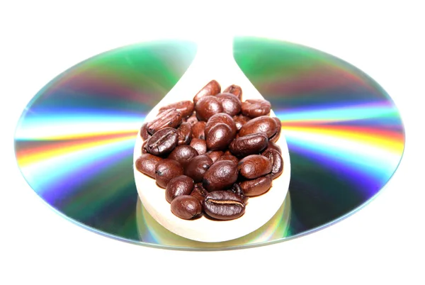 Granos de café en una cuchara de madera en un disco DVD — Foto de Stock