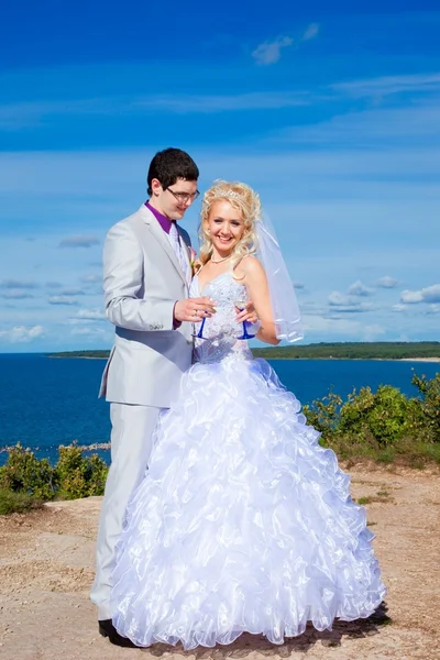 Happy groom and bride on a sea coast — Stock Photo, Image