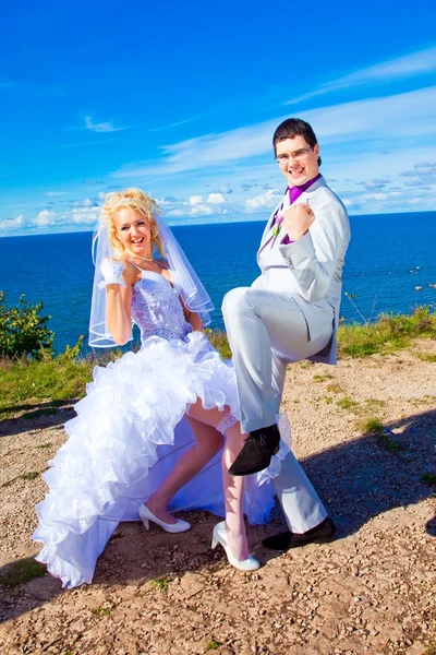 Mariée et marié heureux sur une côte de la mer — Photo