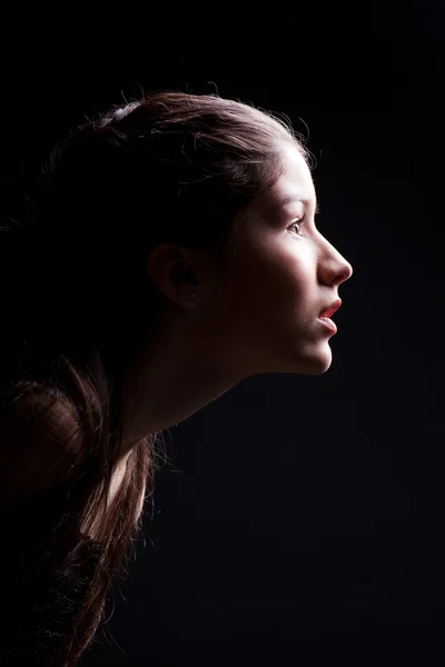 黒に光を前方に永続的な若い女の子 — ストック写真