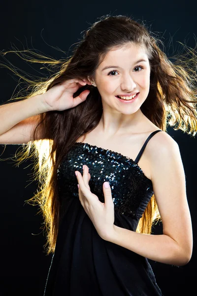 Κορίτσι έφηβος που παρουσιάζει όμορφο υγιή μακριά σκούρα μαλλιά σε μαύρο — Φωτογραφία Αρχείου