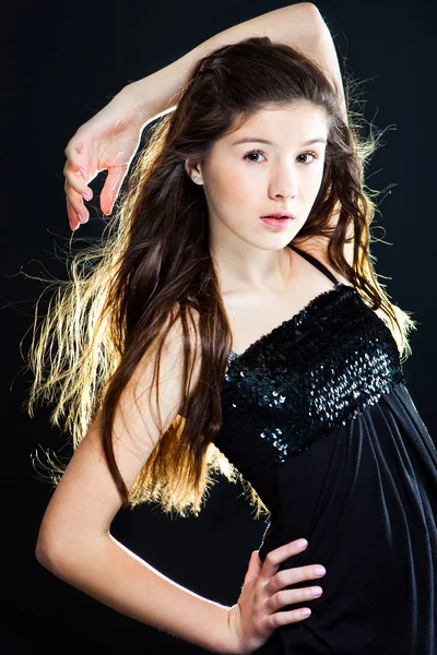 Cute teenager girl with beautiful long dark hair on black — Stock Photo, Image