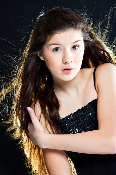 Cute tiener meisje met mooie lange donkere haren op zwart — Stockfoto