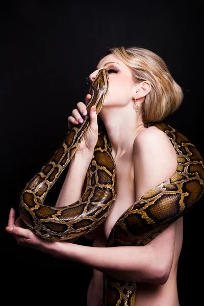 Kyss av pen, blond kvinne med pyton på svart – stockfoto