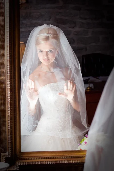 Όμορφη νύφη σε λευκό μπροστά από τον καθρέφτη — Φωτογραφία Αρχείου
