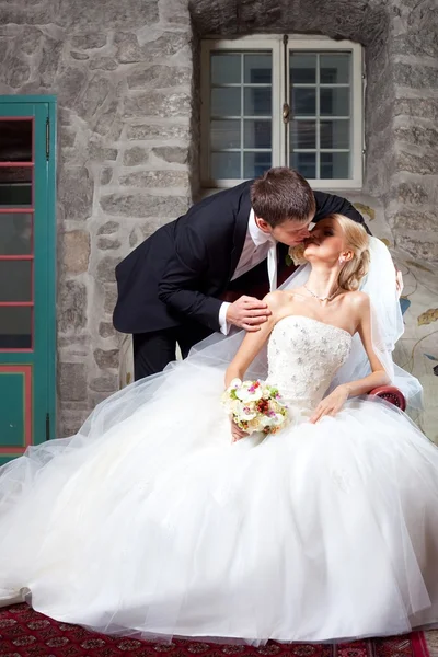Красивый жених и невеста целуются в старом интерьере — стоковое фото