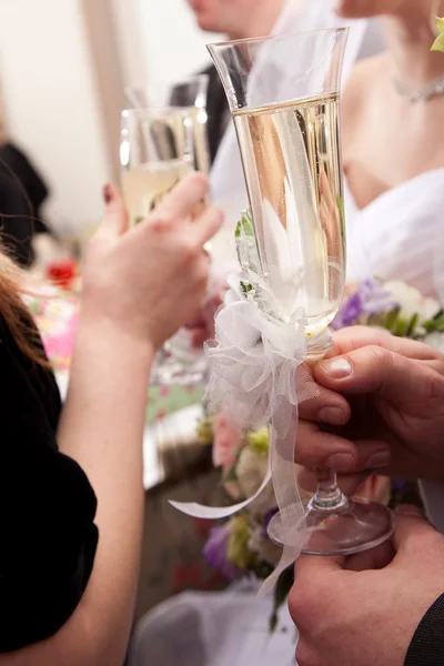 Wedding decorated glasses in hands of groom and bride — Stock Photo, Image
