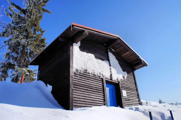 Houten huis in de winter — Stockfoto