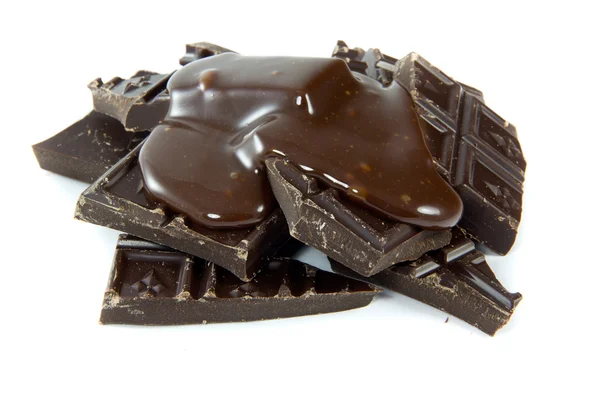 Gebrochene Schokolade mit geschmolzener Schokolade lizenzfreie Stockfotos