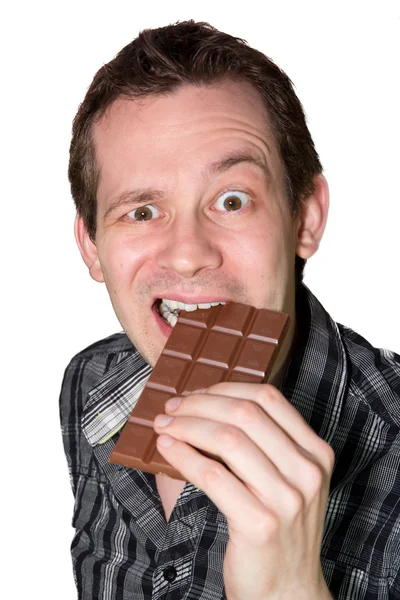 Mies syö kovaa suklaata. tekijänoikeusvapaita kuvapankkikuvia
