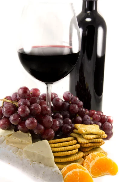 Stock image Bottle of red wine with some grapes