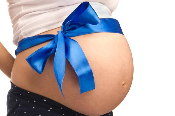 Abdomen de mujer embarazada joven con una cinta azul — Foto de Stock