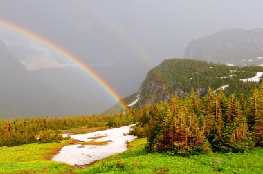 Double rainbow in a mountain storm clipart