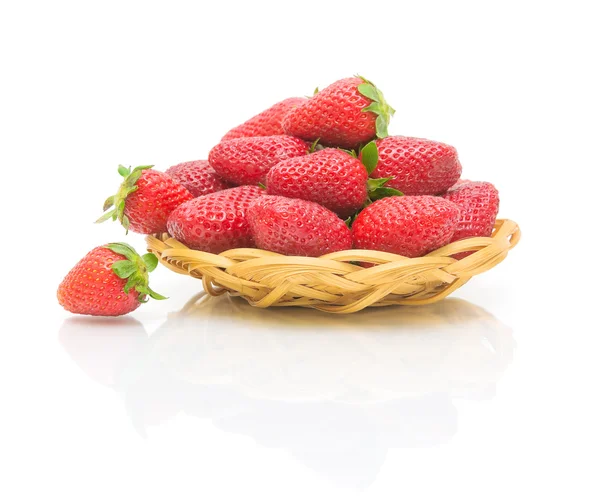 Fresas en un tazón de paja sobre un fondo blanco — Foto de Stock