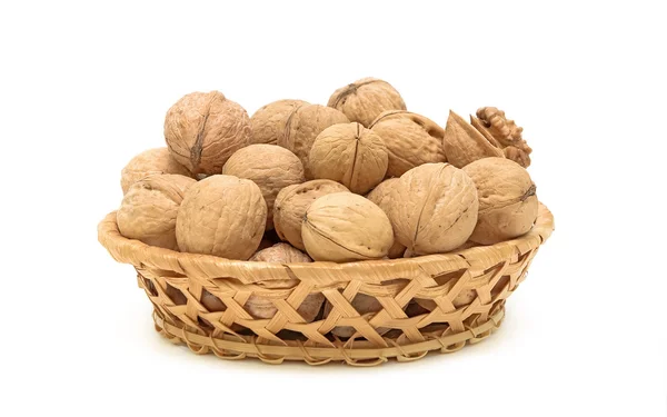 Ořechy v proutěném koši na bílém pozadí — Stock fotografie