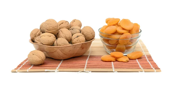 Walnuts and dried apricots on a white background — Stock Photo, Image