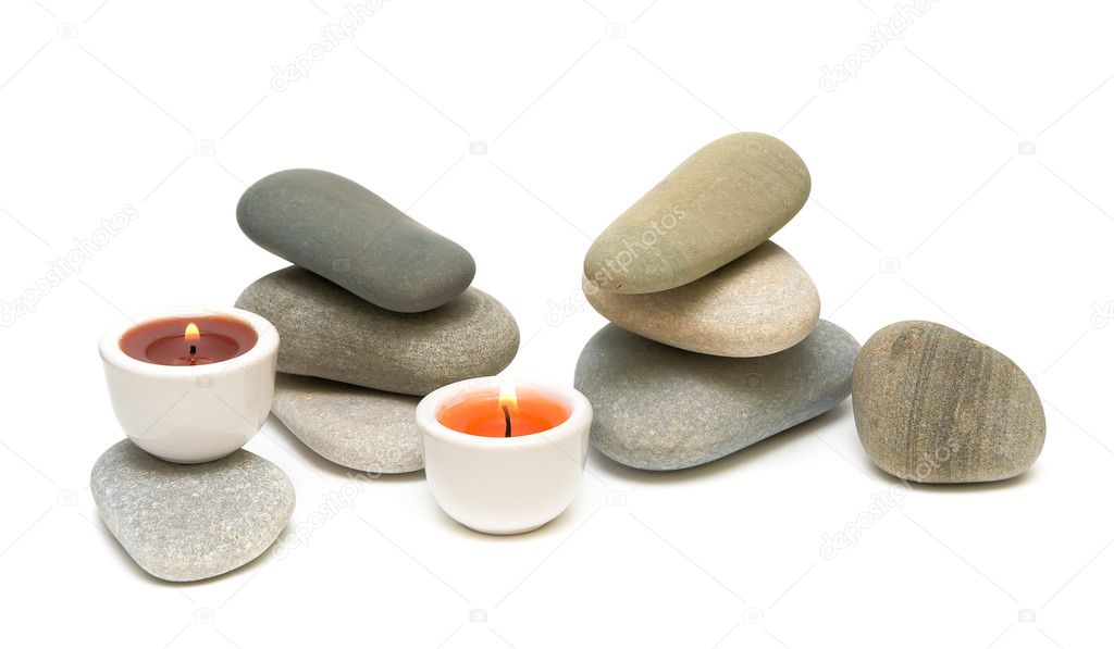 Candles and sea pebbles on white background