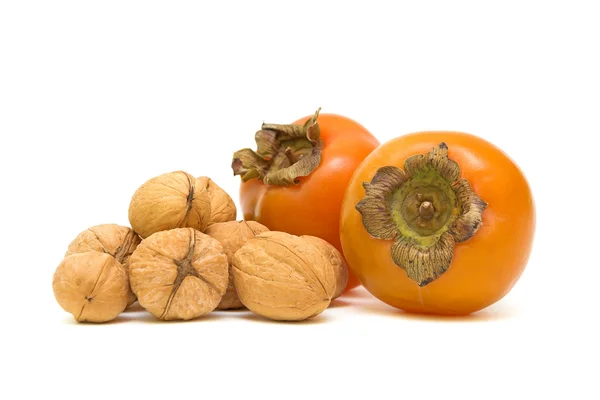 Persimmons and walnuts on white background — Stock Photo, Image