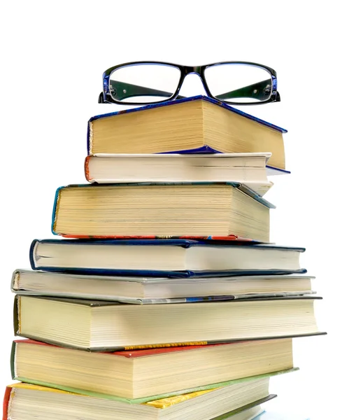 メガネと白い背景の上の本のスタック — ストック写真