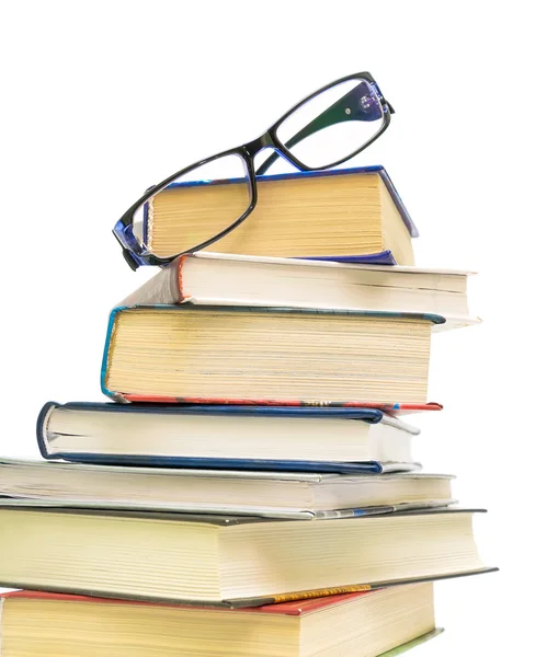 Óculos em uma pilha de livros sobre fundo branco close-up — Fotografia de Stock