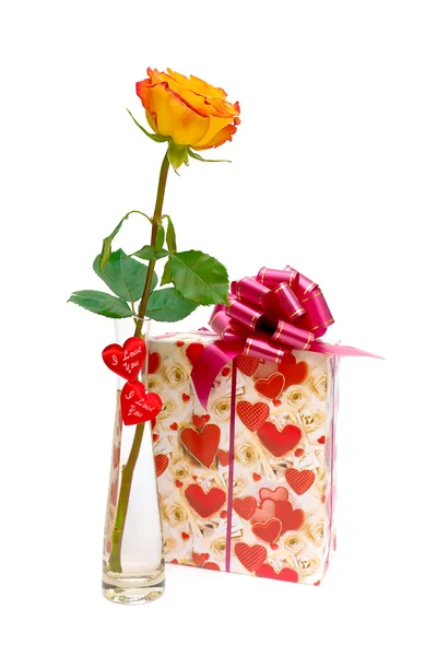 Rose und ein Geschenk auf weißem Hintergrund — Stockfoto