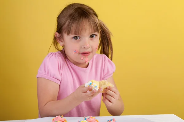 Dwaze meisje eten een cupcake — Stockfoto