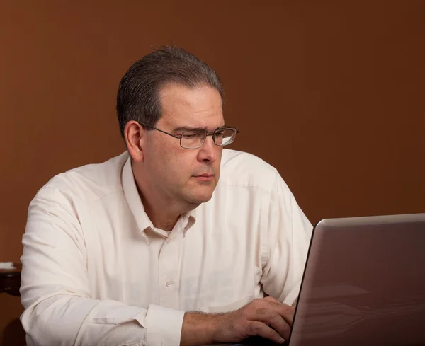 컴퓨터에서 scowling 중간 나이 남자 — 스톡 사진