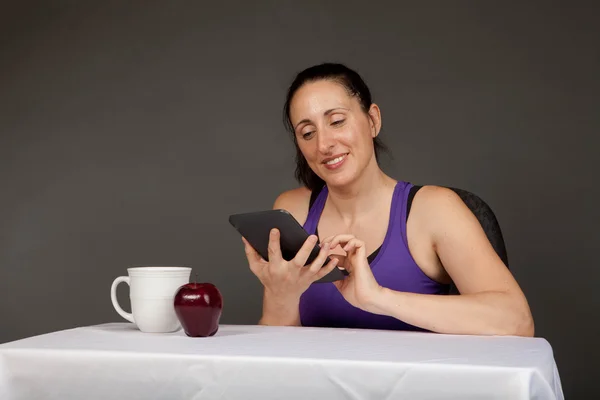 Happy fit girl with an e-reader — Stock Photo, Image