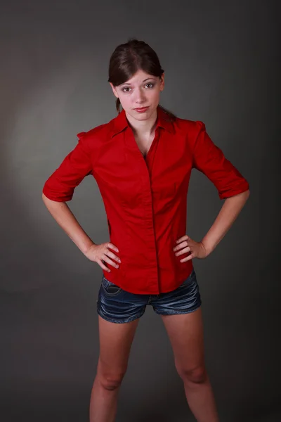 愤怒黑发的十几岁的女孩穿着短裤和红色衬衫 — 图库照片