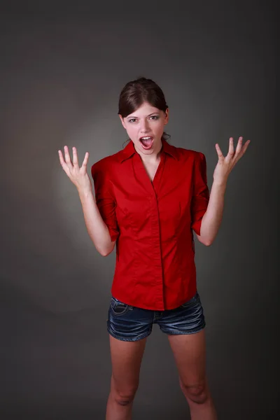 ショート パンツと赤いシャツで怒っているブルネット十代の少女 — ストック写真