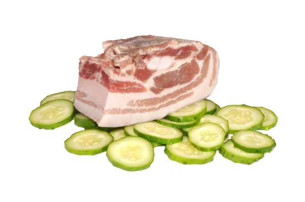 Het stuk van varkensvlees op komkommers — Stockfoto