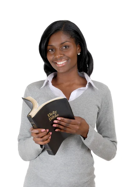 Junge Frau lächelt mit geöffneter Bibel Stockbild