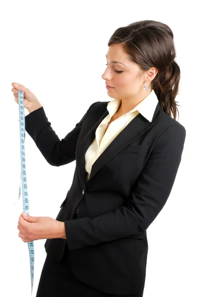Mujer de negocios mirando una cinta métrica — Foto de Stock