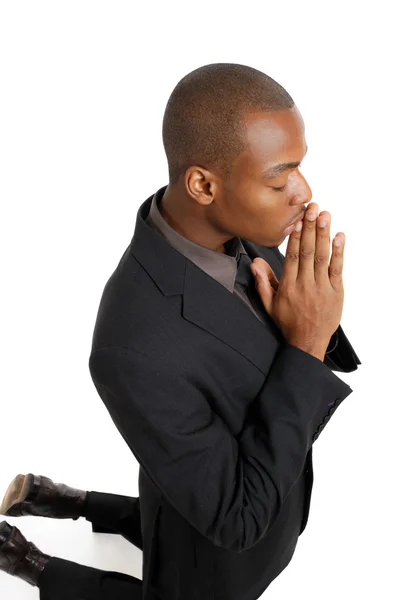 Hombre de negocios rezando de rodillas Fotos de stock